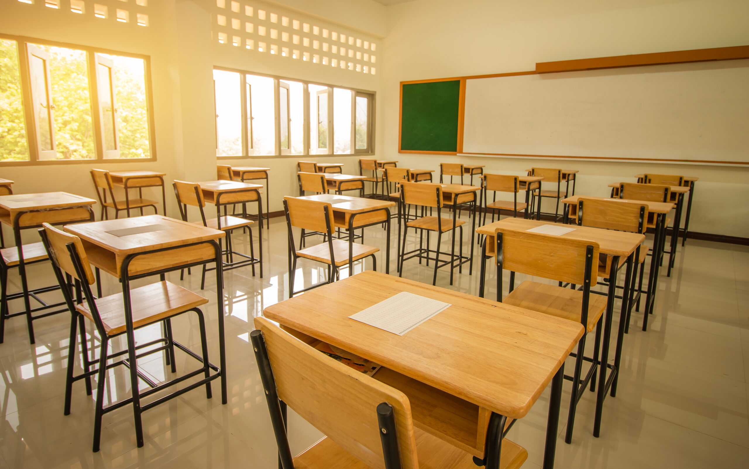 School classroom with test exam paper on desks chair wood, and b